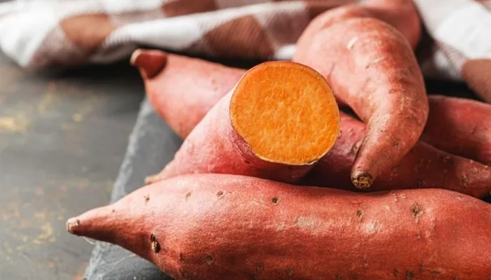 A roasted sweet potato with skin, split open.