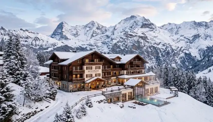 An alpine wellness hotel nestled in the snow-dusted mountains of Switzerland, offering a cool climate retreat.